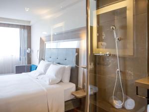 a hotel room with a bed and a shower at Novotel RJ Porto Atlantico in Rio de Janeiro