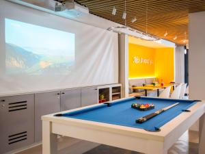 una mesa de billar en una habitación con una pantalla grande en ibis Styles Nice Cap 3000 Aéroport en Saint-Laurent-du-Var