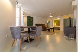 a dining room with a table and chairs and a living room at Apartment Adriatico Eterno 2 in Rovinj