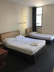 a hotel room with two beds and a window at Darwin Poinciana Inn in Darwin