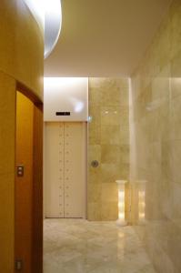 a bathroom with a shower and a white door at Hotel South Garden Hamamatsu in Hamamatsu
