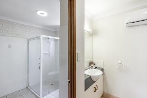 
a bathroom with a shower, sink, and toilet at Clifford Gardens Motor Inn in Toowoomba
