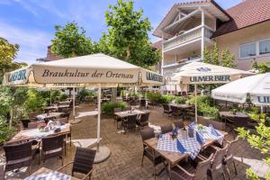 eine Außenterrasse mit Tischen und Sonnenschirmen in einem Restaurant in der Unterkunft Hotel Linde Durbach in Durbach