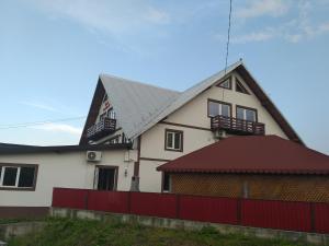 een huis met een rood hek ervoor bij Vila AnneMaryy in Arbore