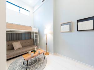 una sala de estar con un sofá y una mesa en TRIP POD TAKASAGO A, en Fukuoka