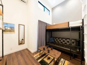 una sala de estar con un sofá y una mesa en TRIP POD TAKASAGO A, en Fukuoka