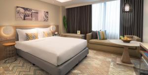 a bedroom with a large bed and a large window at Citadines Cebu City in Cebu City