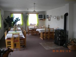 un comedor con 2 mesas y sillas y una habitación con mesas y sillas en Pension Holubec en Benecko