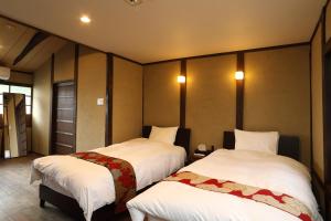 a room with two beds with white sheets at Kyoto Gion No Yado in Kyoto