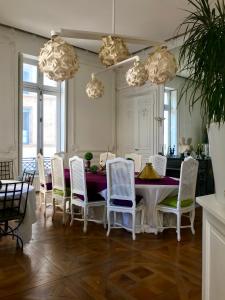 a dining room with a table and white chairs at Chez Madame de Bellecour in Lyon