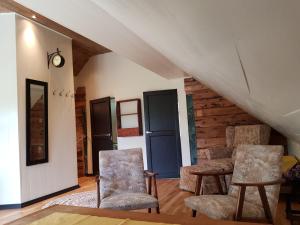 a living room with two chairs and a staircase at Rødseter Gjestegård in Fjarland