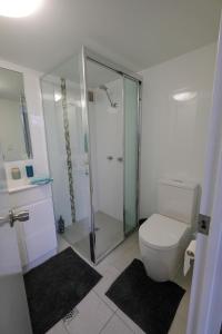 a white toilet sitting next to a shower in a bathroom at Sanctuary Beach Retreat in Gold Coast