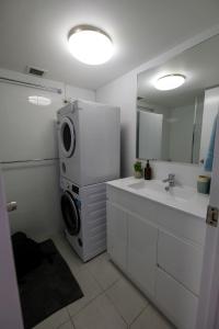 uma casa de banho com um lavatório e uma máquina de lavar roupa em Sanctuary Beach Retreat em Gold Coast