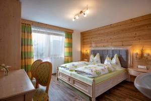 a bedroom with a bed with a wooden wall at Saibatenhof in Hainzenberg