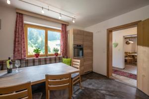 a kitchen and dining room with a table and chairs at Saibatenhof in Hainzenberg