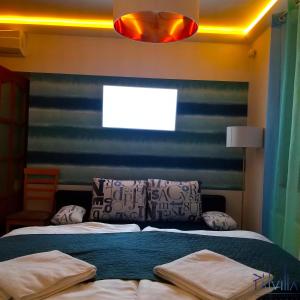 1 dormitorio con 1 cama con una pared de rayas azul y blanco en Pál Villa - Premium Apartments - Kecskemét, en Kecskemét