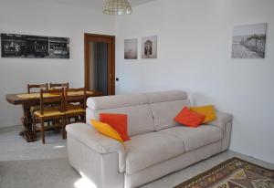 a living room with a white couch with colorful pillows at CASA STEFANIA, APPARTAMENTO IN COLLINA in Salsomaggiore Terme
