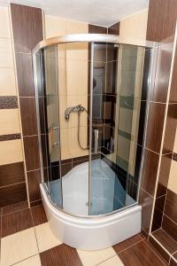 a bathroom with a tub with a glass shower at Privát U Mara in Poprad