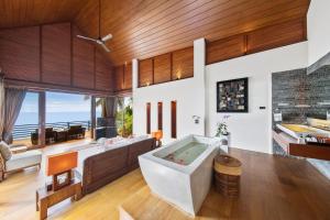 a living room with a large tub and a couch at Baan Hinyai in Lamai