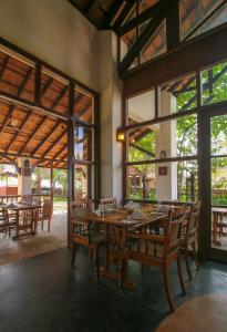 a dining room with a large wooden table and chairs at Punnamada Resort in Alleppey