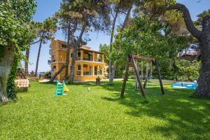 um quintal com um parque infantil e uma casa em Zarkadis Beach Apartments em Tsilivi