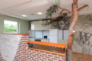 a kitchen with a brick wall and a tree at Naujoji Karkle in Karklė