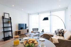 sala de estar con mesa y sofá en Petit Luxe Tobella Esquerra, en Terrassa