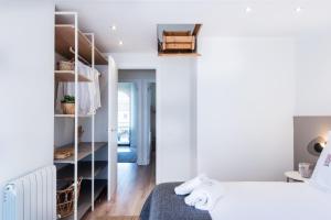 a white bedroom with a bed and a closet at Petit Luxe Tobella Esquerra in Terrassa