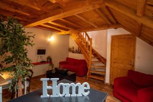 a living room with a red couch and a staircase at Loire-Gerbier-Mézenc in Sainte-Eulalie