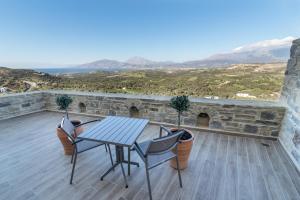 a table and chairs on a patio with a view at Villa Ovgoro in Kamilari