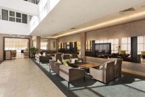 a lobby with chairs and a table and a television at Amansari Hotel Desaru in Desaru