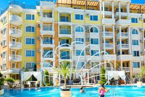 a pool in front of a building with a water park at Sweet Homes Apartments in Sunny Beach