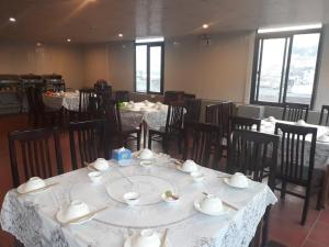 a dining room with tables and chairs with white linens at Vip Sapa Hotel in Sa Pa