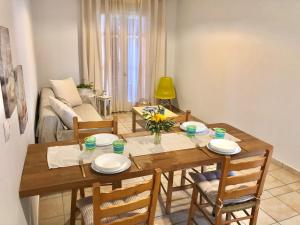 - une salle à manger avec une table et des chaises en bois dans l'établissement NIKOLETA'S CORFU APARTMENTS, à Gouviá