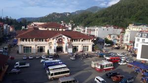 a large building in a city with cars and buses at Vip Sapa Hotel in Sa Pa