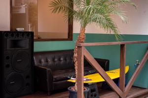 a palm tree in a living room with a surfboard at Hostel Chill Out in Osaka