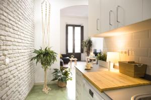 a kitchen and living room with a white brick wall at Mediterranean Way - Apartamento Canela in Tarragona