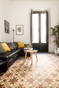 a living room with a black couch and a table at Mediterranean Way - Apartamento Canela in Tarragona