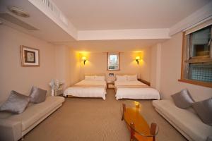 Giường trong phòng chung tại Tian Long Hotel