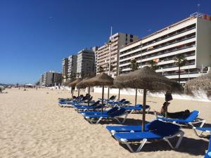 un grupo de sillas y sombrillas en una playa en Luxury Oceanfront triplex in Cadiz, en Cádiz