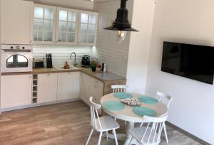 a kitchen with a table and chairs and a sink at Apartament TOP Pięć Mórz basen&SPA in Sianozety