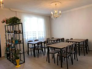 a dining room with tables and chairs and a chandelier at Hotel CHARLI in Gonio