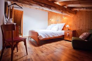 a bedroom with a bed and a chair at Chalet L’Etagne in Bessans