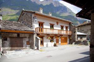 a building with a balcony on the side of a street at Chalet L’Etagne in Bessans