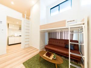 a room with a loft bed with a couch and a table at TRIP POD YOSHIZUKA C in Fukuoka
