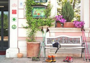 a bench in front of a building with plants at Hotel Liberty in Levico Terme