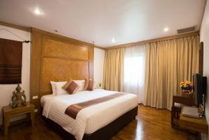 
a bedroom with a large bed and a large window at The Tarntawan Hotel Surawong Bangkok in Bangkok

