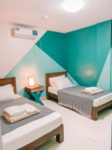 2 camas en una habitación con una pared verde en The NEST, Tagaytay en Tagaytay