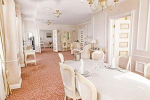 a dining room with a white table and chairs at Europe Hotel in Minsk