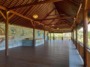 a covered walkway in a building with a painting on the wall at Lala Homestay Bingin in Uluwatu